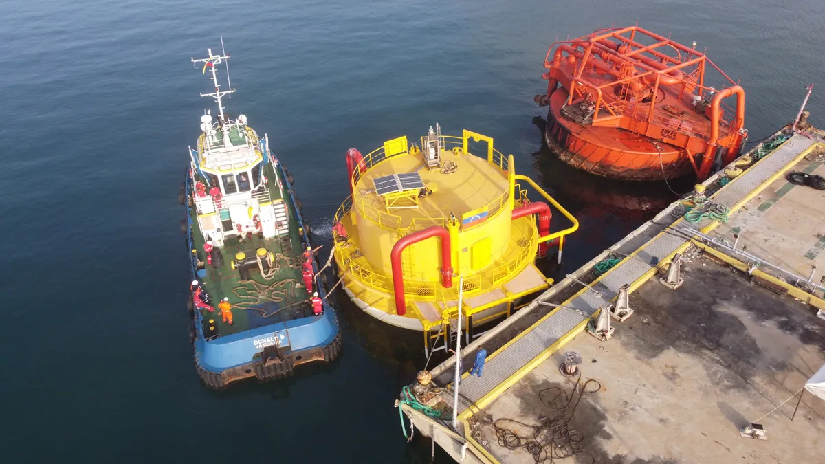 Single point mooring and conventional buoy mooring units berthed alongside the jetty, with a support tug.